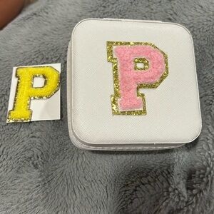Small jewelry travel case with a “p” and extra p sticker.